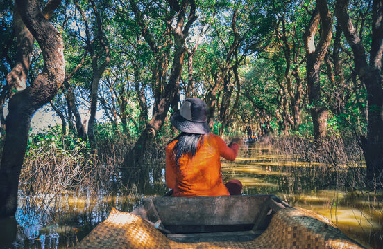 A woman floating on a boat in the village built on the Tonle Sap lake. People living on the water in the city of Siem Reap, Cambodia