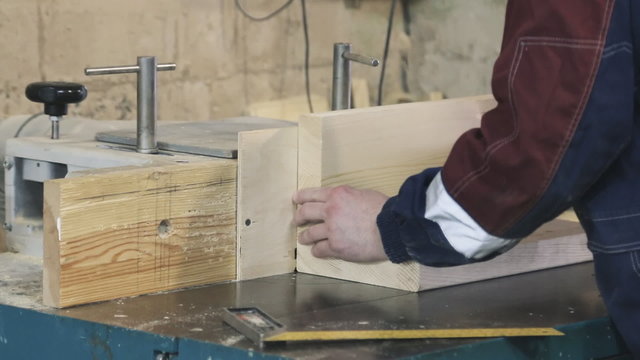 Close-up of running a board of lumber through a wood jointer power tool