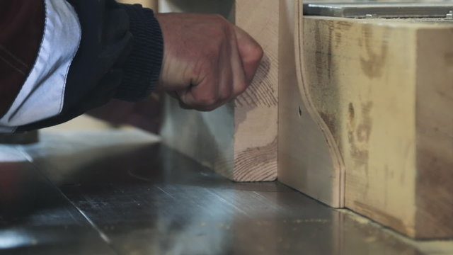 Close-up of running a board of lumber through a wood jointer power tool