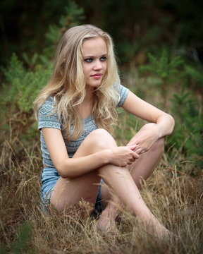 Pretty Blond Teenager Sitting In The Grass