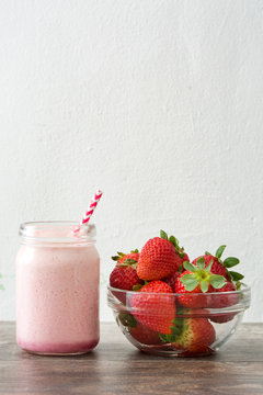 Delicious strawberry smoothie on wood
