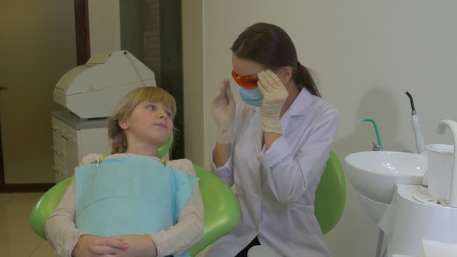 Dentist Using uv Dental Lamp Show the Thumb Patient Doctor is Treating a Teeth of a Patient Teenage Girl at Dental Treatment Room Visit to the Dentist