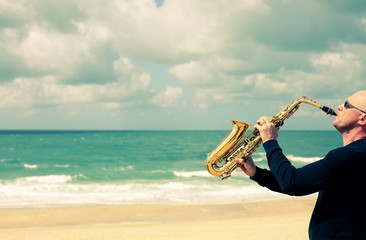 Saxophonist playing on saxophone on blue sky background