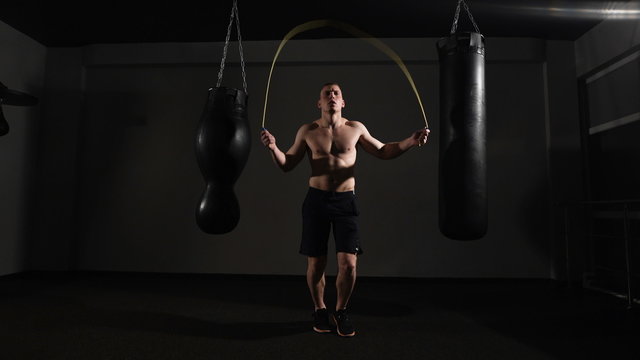 Young boxer training with a skipping rope as he practices his endurance, 