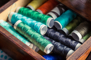 Old tailor's wooden box with threads, needles and buttons
