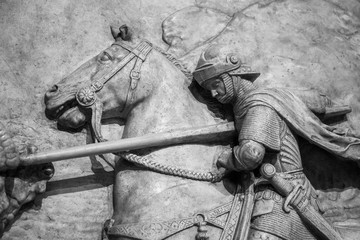 Bas-relief of knight with a spear striking dragon 