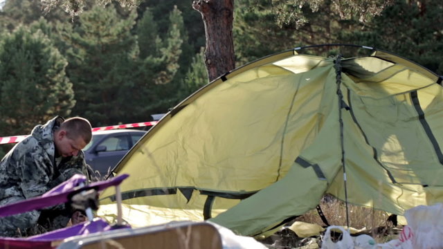Two unpack the tent, put the camp. In autumn, the family came to fish and hunt. The tent is not a big, double