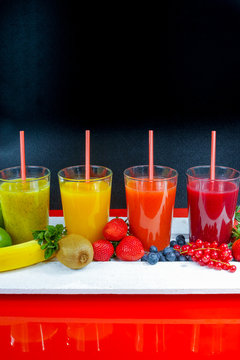 Colofrul fresh pressed fruit juices in tall glasses with fruits