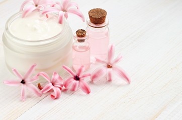 Cosmetic facial cream, bottles with aroma oil, hyacinth flowers. Natural beauty treatment. 