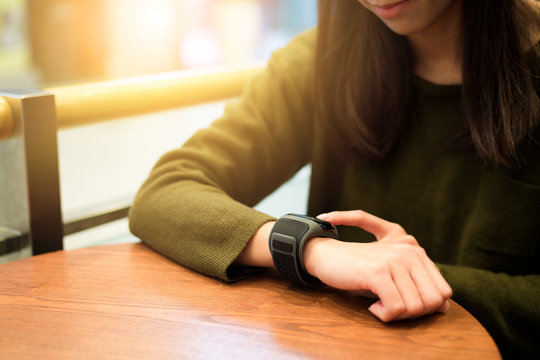 Woman touch on smart watch in cafe