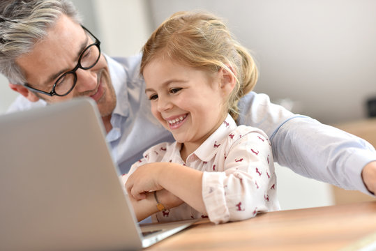 Man with little girl using laptop computer