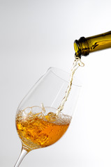 White wine pouring in a glass from a bottle