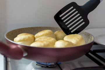 Homemade donuts being fried in a pan