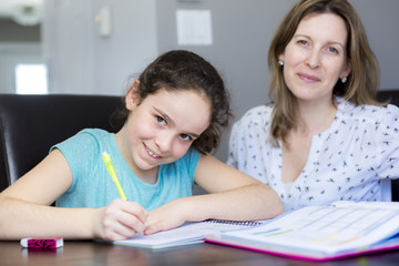 Fototapeta premium Mature mother helping her child with homework at home.