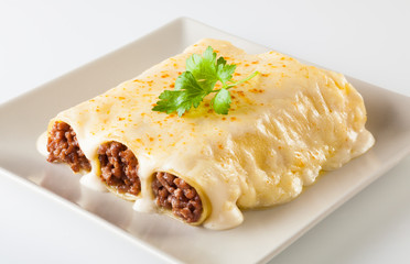 Delicious meat filled pasta on a plate. Italian cannelloni, Spanish canelones.