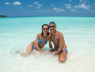 Obraz premium Couple in the 40s relaxing on a wonderful tropical beach