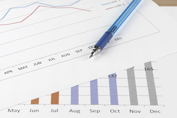 pen and graph on wood table.