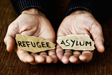 pieces of paper with words refugee and asylum