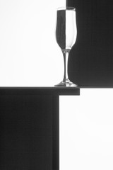 Black and white composition with empty wineglass on a table.