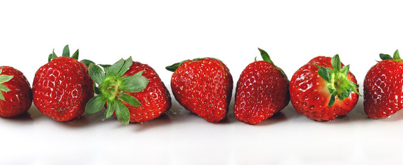 Obraz na płótnie Canvas Ripe red strawberries laid in length on a white background. Panorama. Banner.