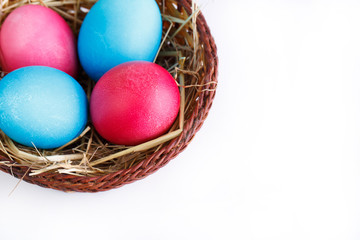 Painted eggs in basket isolated on white background.