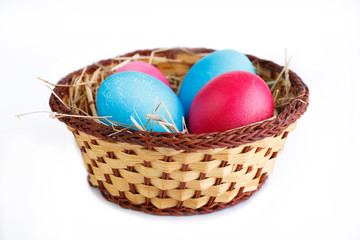 Fototapeta na wymiar Painted eggs in basket isolated on white background.