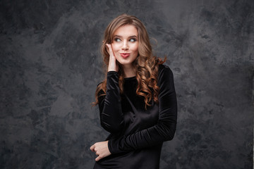 Fototapeta premium Amusing woman with long curly hair making funny duck face