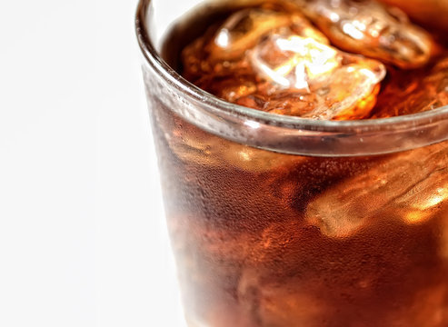 Cold cola with ice in a glass on a white background
