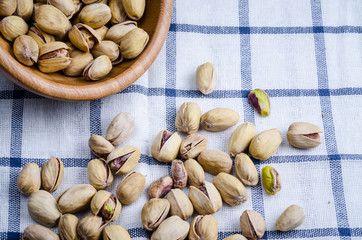 roasted and salted pistachios on table cloth.
