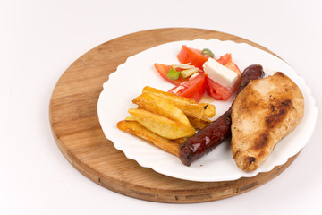 Grilled homemade red sausages with potatoes and tomatoes