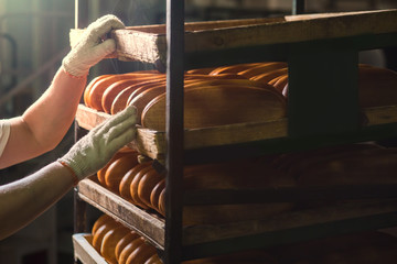 Seller puts bread on the shelf.