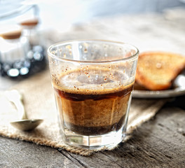 Coffee with milk in a glass on a wooden background
