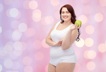 happy plus size woman in underwear with apple