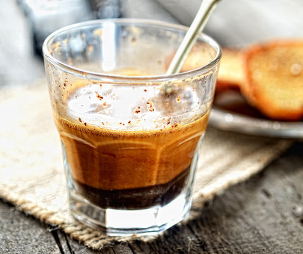 Coffee with milk in a glass on a wooden background
