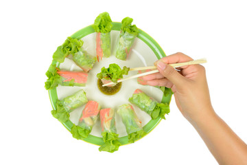 Salad rolls with hand hold chopsticks dipping in seafood sauce