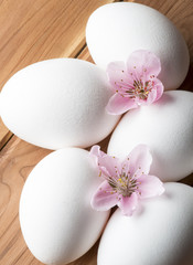Obraz na płótnie Canvas eggs with flower of peach on the wooden table