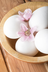 Obraz na płótnie Canvas eggs with flower of peach on the wooden table