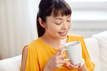 happy asian woman drinking from tea cup