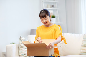 happy asian young woman with parcel box at home