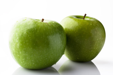 Two green fresh ripe apples on white background from side