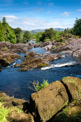 Naklejka na ściany i meble Nature scene with blue water which streams through rocky rapids near Ring of Kerry Ireland