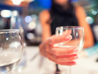 Woman hand holding wine glass at restaurant