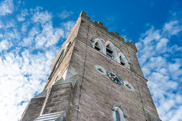 Fototapeta na wymiar Dingle, Ireland: Tower of St. Mary's Church with clock and blue sky