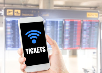 smart phone wi-fi icon word tickets on blurred airport flight schedule