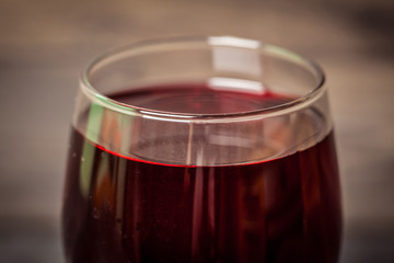 Glass of red wine on wooden table.