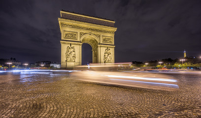 Fototapeta na wymiar Arc de Triomphe and blurred traffic at night