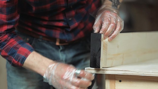 Man processes the wood protective fluid