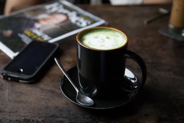 Cup of green tea latte on wood background