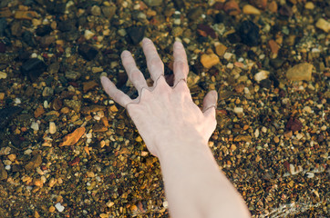 River water theme: the human hand touches the water in the river