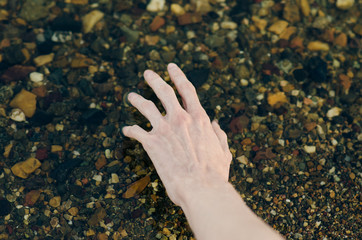 River water theme: the human hand touches the water in the river